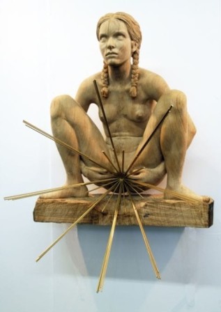 sculpture : des rayons émanent du sexe d'une femme nue accroupie