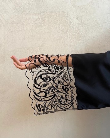Made by Hadal Embroidered onto the sleeve is an Arabic love poem by Palestinian poet Mahmoud Darwish