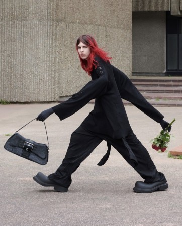 une fashionista en marche à grandes enjambées dans un élégant vêtement ample loin du corps pour profiter des derniers rabais sur la mode