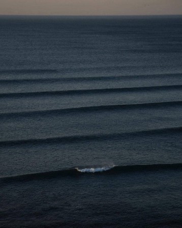 Adam Warmington. parfaites lignes de houle régulière qui avancent vers la côte, « corduroy lines » pour surfeurs toutes les vagues ont commencé petites