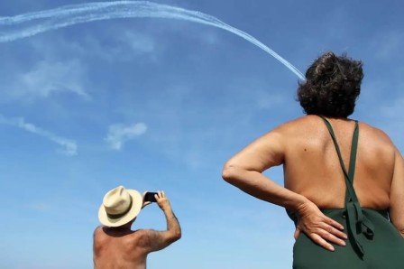 la trace dans le ciel d'un avion à réaction aboutit dans la mise en plis d'une dame brune