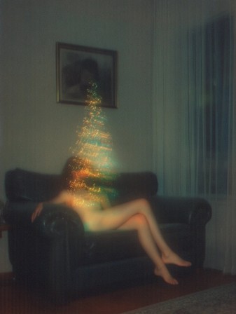 l'image vacillante d'un sapin de Noël se superpose sur la photographie d'une femme assise dans le salon