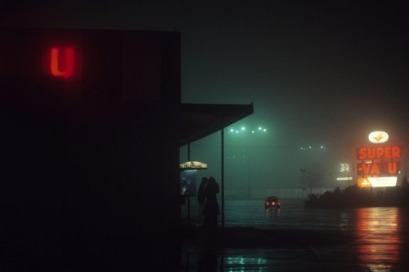 une enseigne U au néon éclaire la nuit brumeuse