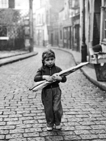 Robert Doisneau. A young girl carries two baguettes in a lonely street in Paris in 1957 j'ai deux baguettes mon pays et Paris