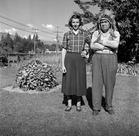 Vivian Maier posant aux côtés d'un homme des premières nations portant une coiffe de plumes