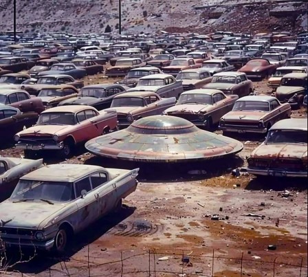 une soucoupe garée parmi des voitures abandonnées