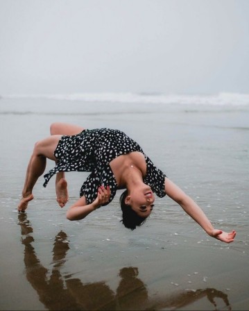 sur la plage, une jeune femme figée par la photographie dans une pause à la grâce impossible, comme si elle n'était pas en train de tomber sur le dos